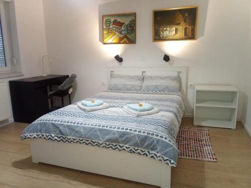 1 dormitorio con 1 cama con 2 toallas en Charming flat, city center with free parking, en Varaždin