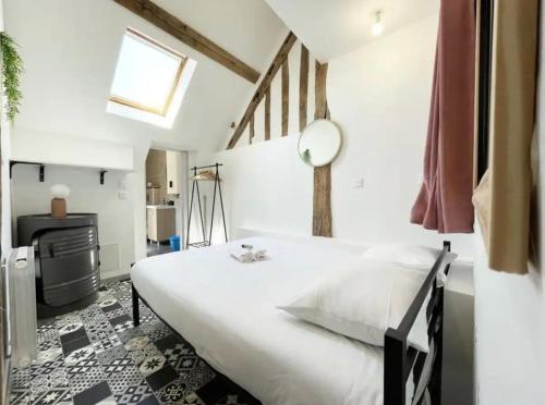 ein Schlafzimmer mit einem großen weißen Bett und einem Spiegel in der Unterkunft The Kiki's Home in Chartres