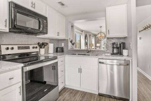 a kitchen with white cabinets and stainless steel appliances at Harbor Island F206 in Oceanmarsh Subdivision