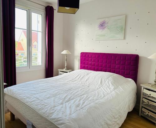 un letto con testiera viola in una camera da letto di L'AVOCETTE a Cayeux-sur-Mer