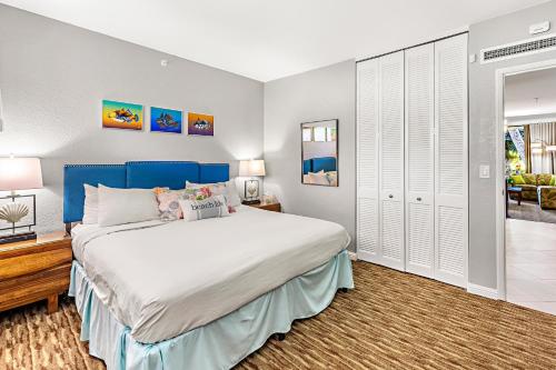 a bedroom with a large bed with a blue headboard at Kaanapali Shores 144 in Kahana