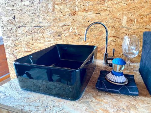 a black sink with a faucet next to a glass at Off-Grid Boat Experience - Stay Zero Footprint in Utrecht