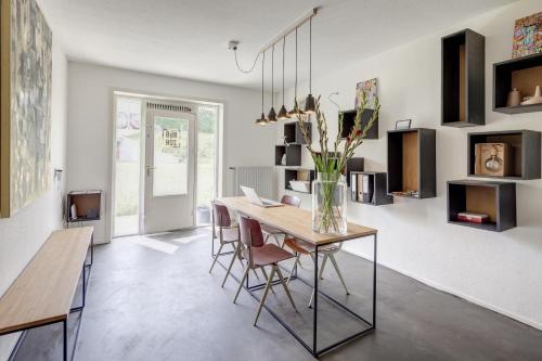 a dining room with a table with chairs and a vase with flowers at Apartment Hotel Zuid Oost Heesterveld BnB ZOH in Amsterdam