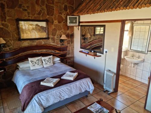 - une chambre avec un lit et un lavabo dans l'établissement Garingboom Guest Farm, à Springfontein