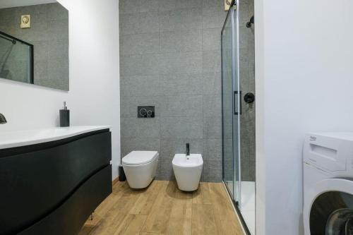 a bathroom with a toilet and a glass shower at Intero alloggio: appartamento in Bergamo