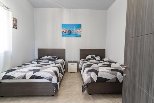 two beds sitting next to each other in a bedroom at Luxurious Beach Apartment in Birżebbuġa