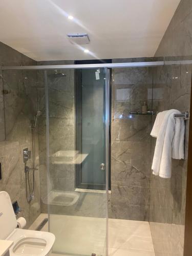 a bathroom with a glass shower with a toilet at Solaris in Accra