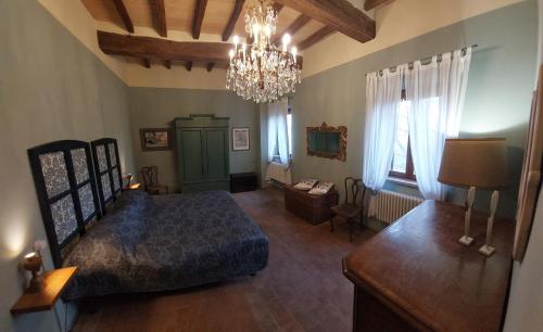een slaapkamer met een groot bed en een kroonluchter bij Il Nido exclusive apartment Parma in Parma