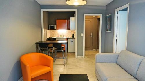 un salon avec un canapé et une cuisine dans l'établissement Proche Croisette, T2 avec terrasse, By Palmazur, à Cannes