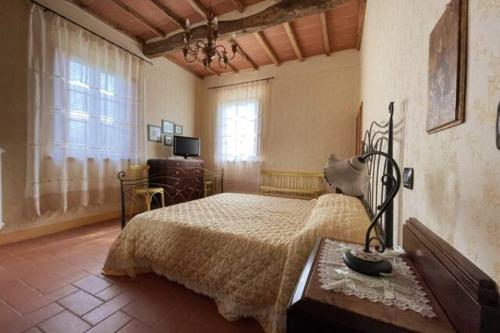 een slaapkamer met een bed en een tafel met een lamp bij Art Apartment Agriturismo il Vecchio Merlo in Larciano