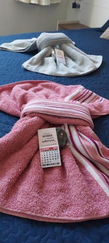 two pink towels on a table with a price tag at Apê Aconchegante in Recife