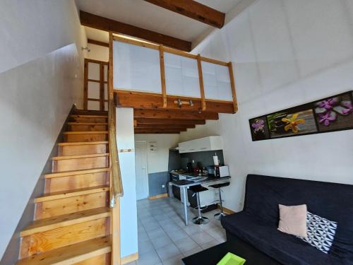 un salon avec un escalier menant à une cuisine dans l'établissement Gîte Le Muscat L'Escapade Des Flamants Roses, à Mireval