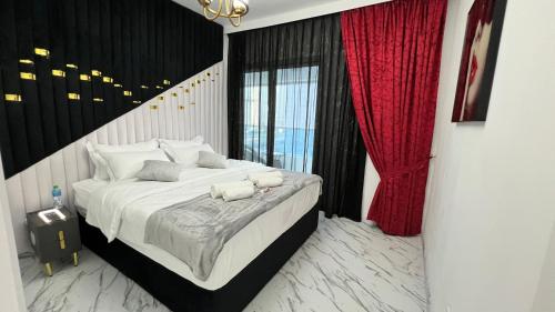 a bedroom with a large bed with red curtains at Stay in heart of Dubai Marina walk to JBR beach in Dubai