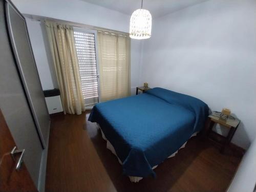 una camera da letto con un letto blu e una finestra di Playa Grande a Mar del Plata