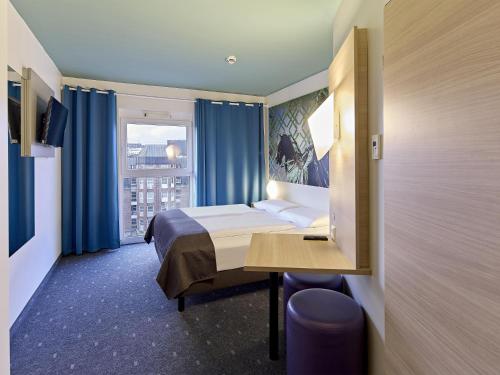 une chambre d'hôtel avec un lit et une fenêtre dans l'établissement B&B Hotel Dortmund-City, à Dortmund