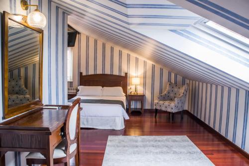 a bedroom with a bed and a desk and a table at Hotel A Casa Do Rio in Padrón