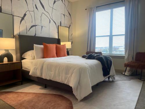 a bedroom with a large bed with orange pillows at Cityscape Haven: Home Base for City Adventures in Houston