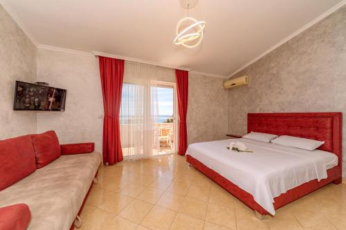 a bedroom with a large bed and a couch at Ani Lux in Dobra Voda