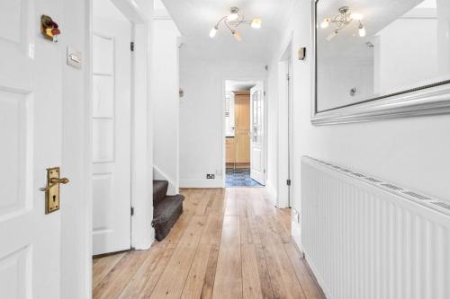 un pasillo con paredes blancas y suelo de madera dura en Bramcote Lane Spacious 5 BR House en Nottingham