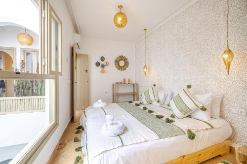 1 dormitorio con 1 cama blanca grande y toallas. en Riad Agan/Exclusive&New/Pool/Breakfast included, en Marrakech