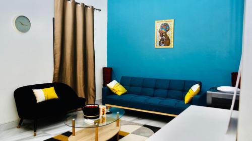 a living room with a blue couch and a chair at Grand Appartement LUXE secteur Mamelles et Monument de la renaissance in Ouakam
