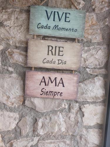 four wooden signs on a stone wall at Adega D'Aldeia 