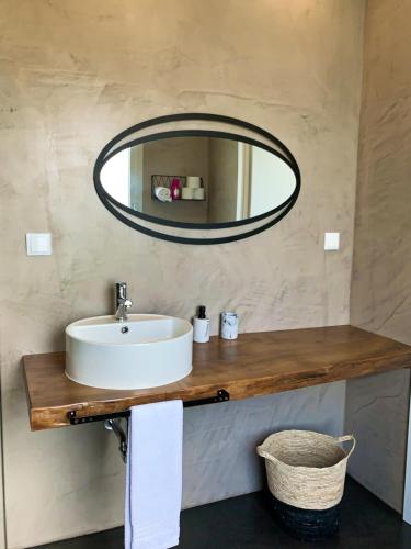a bathroom with a sink and a mirror at Adega D'Aldeia com piscina e jacuzzi in Ulmeiro