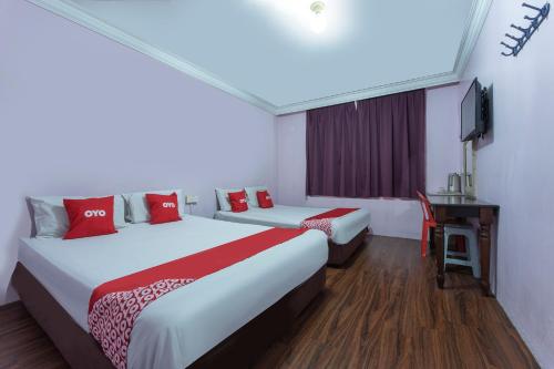 a hotel room with two beds and a desk at Apollo Hotel Johor Bharu in Johor Bahru