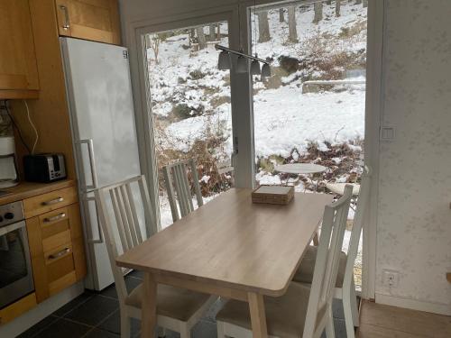 une table et des chaises dans une cuisine avec une fenêtre dans l'établissement House with green garden, Göteborg, 6 beds, à Lindome