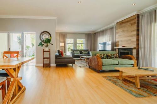 a living room with a couch and a table at Sidwell Gardens, Adjacent to Kingswood Estate in George