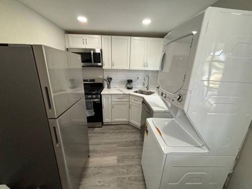 a kitchen with white cabinets and a white refrigerator at Blue house in Hampden in Baltimore