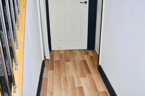 a door leading to a room with a wooden floor at Beeston House 3 BR and FREE Parking in Beeston