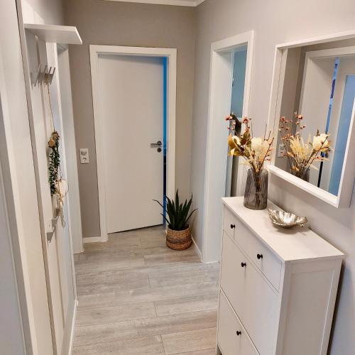 a hallway with a white cabinet and a white door at Apartment am Hochwald in Reinhardtsdorf
