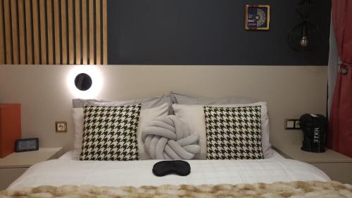 a bedroom with a white bed with black and white pillows at Pinewood ANG luxurious apartment A43, Borovets Gardens in Borovets