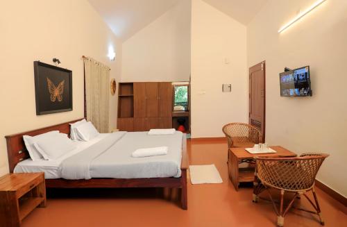um quarto com uma cama, uma mesa e uma secretária em Dhanagiri Home Stay em Vythiri