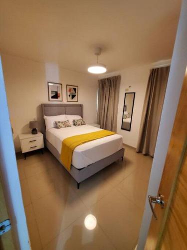 ein Schlafzimmer mit einem Bett mit einer gelben Decke in der Unterkunft Cómodo Apartamento en San Isidro in Mendoza