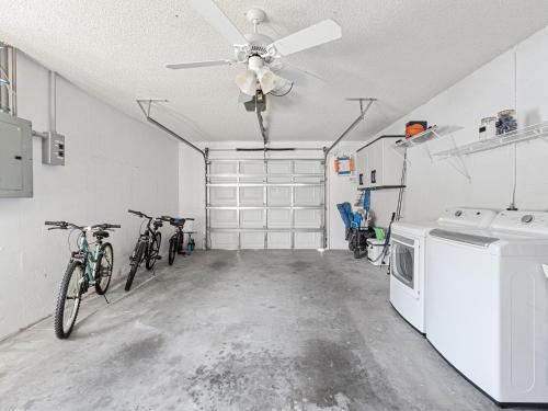 a garage with bikes parked in it with a ceiling fan at Beautiful Home in Venice - 10 min from beaches! in Venice