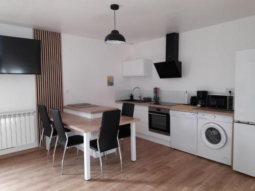 une cuisine avec une table et des chaises dans une cuisine dans l'établissement Appartement T2, avec Terrasse., à La Roche-sur-Yon