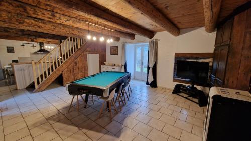 - un salon avec un billard et un escalier dans l'établissement Maison de campagne, à Saint-Étienne-Lardeyrol