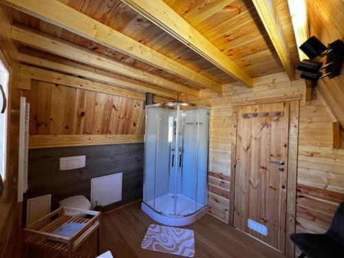 a bathroom with a shower in a wooden cabin at Tiny House Ardennes in Fromelennes