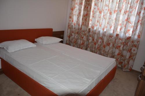 a bedroom with a bed and a window with curtains at VIP CLUB Dolphin Coast in Sunny Beach