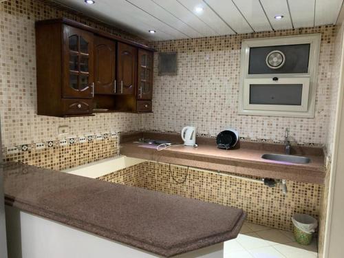 eine Küche mit einer Spüle und einer Mikrowelle in der Unterkunft Sheraton apart-hotel in Kairo