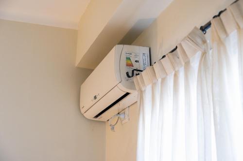 a air conditioner is on a wall next to a window at Alma Mendoza Hotel in Mendoza