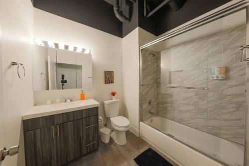 a bathroom with a toilet and a sink and a shower at McCormick 2Br/2Ba family unit for up to 6 guests with Skyline view, Optional Parking & Gym in Chicago