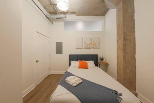 een slaapkamer met een bed met een oranje kussen bij McCormick 2Br/2Ba family unit for up to 6 guests with Skyline view, Optional Parking & Gym in Chicago