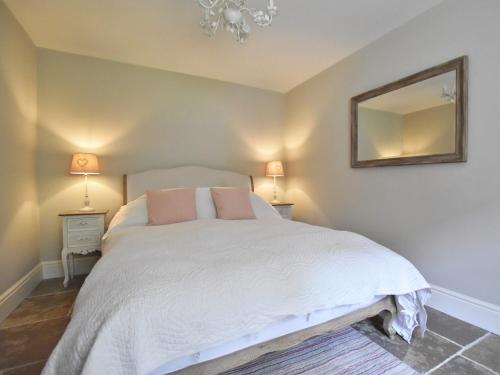 een slaapkamer met een wit bed en een spiegel bij 1 Bed in Whorlton G0121 
