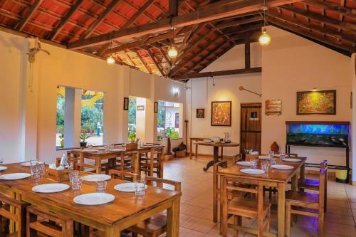 a dining room with wooden tables and chairs at Dhanagiri Homestay Wayanad in Vythiri
