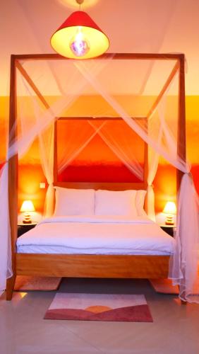 a bedroom with a canopy bed and two lamps at Résidence Tropicale in Libreville