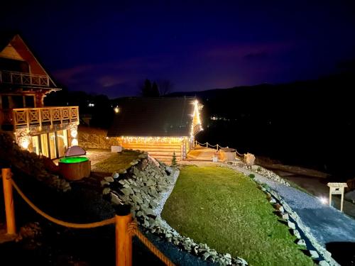 a backyard at night with lights on a house at OVIS HOMES APP in Zawoja