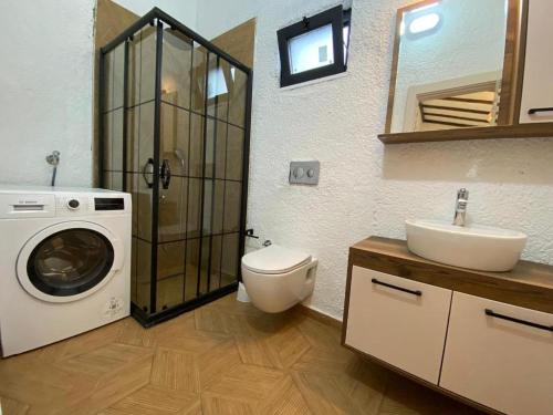 uma casa de banho com uma máquina de lavar roupa e um lavatório em Villa Mustafa em Fethiye